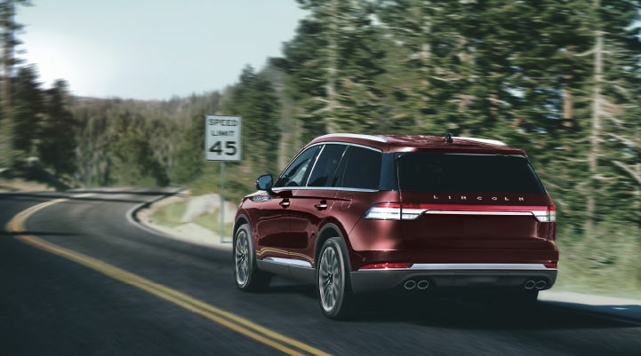 A 2024 Lincoln Aviator® SUV is being driven on a winding mountain road | Mike Reichenbach Lincoln in Florence SC